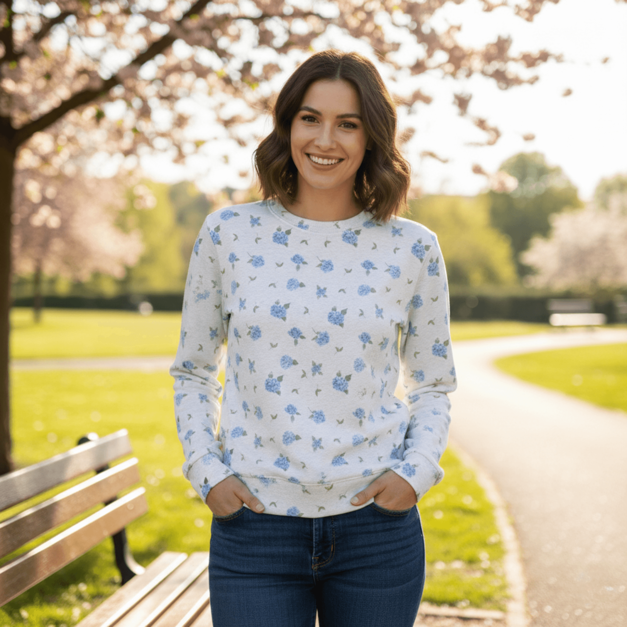 Woman wearing Stylish Cotton Sweatshirt in Camilla's Hydrangea Floral Print in a park with cherry blossom tree