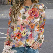 Person wearing a colorful floral sweatshirt on a street.