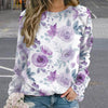 Person wearing a floral sweatshirt with purple flowers on a blurred street background