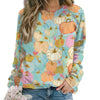 Colorful pumpkin-patterned sweatshirt worn by a person on a white background
